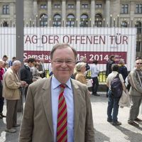 Bundesratspräsident Stephan Weil vor Besuchern und Poster zum Tag der offenen Tür