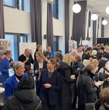 Regionalentwicklungsministerin Osigus steht inmitten einer Menschenmenge auf der Jobmesse in Hannover. Um sie herum sind Menschen an Messeständen im Gespräch.