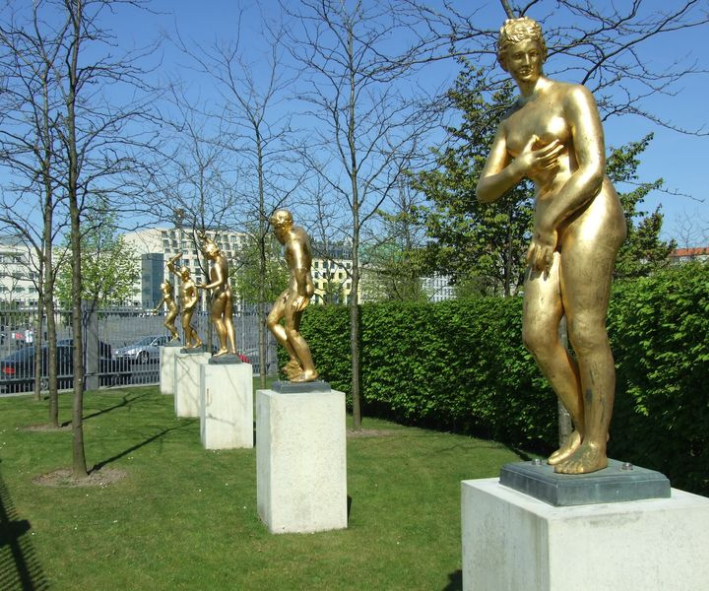 Fünf goldene Barockfiguren auf hohen Betonsockeln im Garten der Landesvertretung.